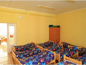 открытая дверь в желтую спальню с яркими детскими кроватками