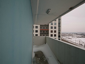 снег на открытом балконе с бетонными плитами большой трехкомнатной квартиры после переезда