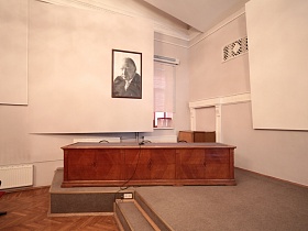 коричневый деревянный стол для президиума в левом крыле сцены просторного актового зала эпохи СССР