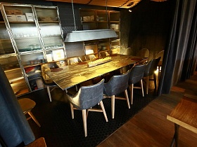 серые кресла вокруг банкетного стола в зонированной комнате за серыми шторами ресторана лофт