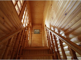 деревянная лестница с резными перилами ведет на второй этаж деревянной дачи музыканта
