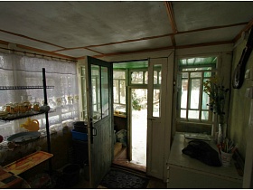 открытые деревянные двери со стеклами на веранду зеленой дачи