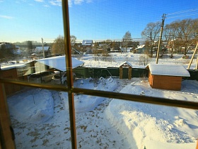 расчищенная от снега площадка с тропинками к входным и въездным воротам современного деревянного дома
