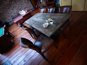 вокруг деревянного стола шесть гладких мягких стула со спинками