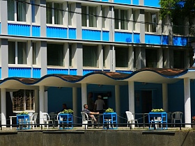 голубые вазоны с живым цветами на открытой террасе с отдельными белыми столиками и белыми стульями со спинкой для отдыхающих гостиницы "Дубна" СССР