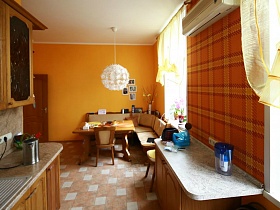 ораньжевые стены яркой кухни с бежево белой плиткой на полу в трехкомнатной квартире