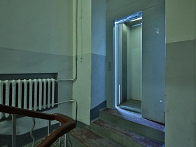 высокие ступени лестницы на выходе из серого подъезда жилого дома советского времени