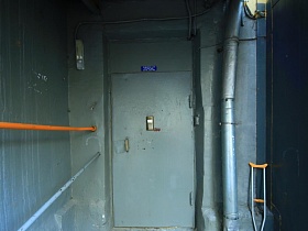 серая металлическая дверь с домофоном на пороге подъезда 12 жилого многоэтажного дома эпохи СССР