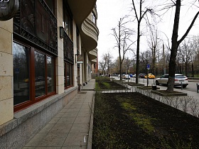 чистая ухоженная территория, выложенная плиткой с разбитымим клумбами под окнами ресторана лофт на Фрунзенской