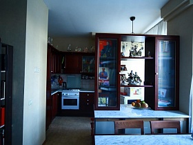коричневая кухня в зонированной комнате стильной квартиры художника в сталинке
