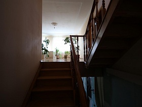 деревянная лестница с резными перилами между этажами семейной уютной дачи с частичным недостроем