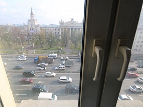 вид из окна квартиры сталинки на проезжую часть дороги с машинами в жилом квартале