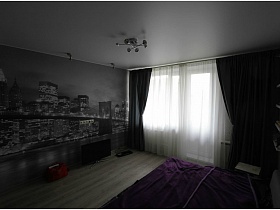 фотообои с вечерним мегаполисом на стене однокомнатной квартиры с серыми шторами на окне с балконной дверью гостиной евро однушки