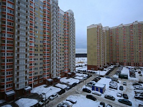 многочисленные припаркованные машины во дворе высотных современных зданий в Новострое