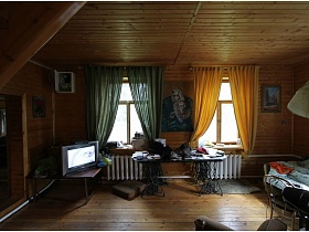 батареи отопительной системы под окнами гостиной деревянной двухэтажной дачи музыканта