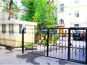 высокий черный забор из металлических прутьев вокруг двора высотного дома на Долгоруковской