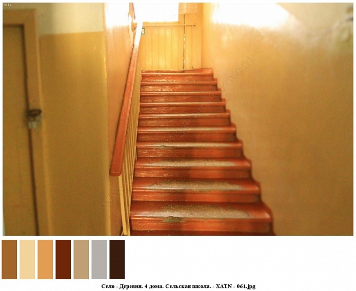 коричневые деревянные ступени лестницы с перилами между этажами в школьном здании на селе