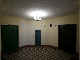 освещенная лестничная площадка с ковриками у входных дверей в жилые квартиры на этаже подъезда на Новослободской