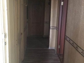 входная дверь в прихожую с бежевыми полосатыми цветочными обоями двухкомнатной квартиры советского времени