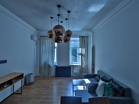 простые предметы мебели в белой гостиной зонированной комнаты современной скандинавской квартиры