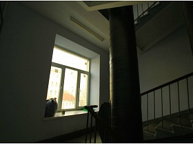окно на лестничной площадке между этажами в подъезде жилого дома