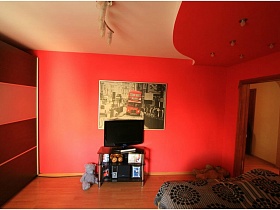 мягкая игрушка у тумбы с телевизором у стены с картиной в спальне с двухцветным потолком в трехкомнатной квартире