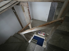 ступени бетонной лестницы в комнате с незаконченным ремонтом жилого дома