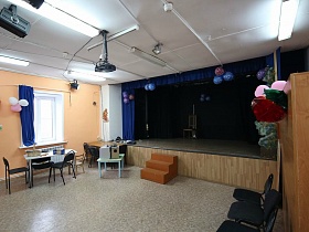 осветительные приборы на белом потолке вместительного зала, направленные на сцену сельского театра в Подмосковье