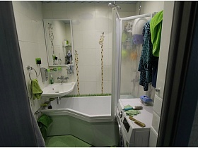 веселые жирафики на зеркале и на плитке над ванной с раздвижной прозрачной шторкой в двухкомнатной квартире
