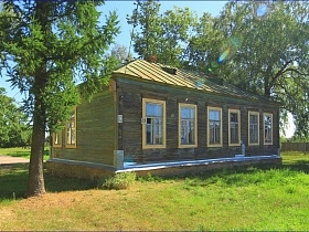 деревянное здание хоз постройки с крышей в тени деревьев