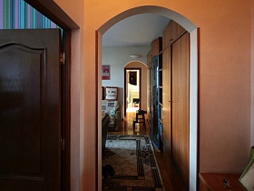 арочный дверной переход из персиковой прихожей в гостиную семейной трешки