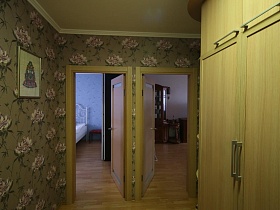 открытые двери в смежные комнаты спальни и гостиной из коридора оливкого цвета актерской трехкомнатной квартиры