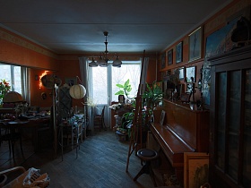 мастерская с коричневыми обоями и белым потолком, смежная с кухней профессорской квартиры в темных тонах