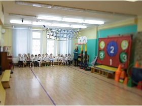 дети на скамеечке светлого  спортивного зала детского сада