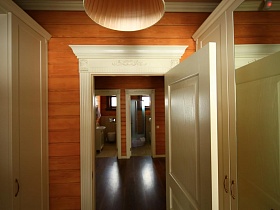 открытая белая дверь в помещение красивого деревянного съемного коттеджа